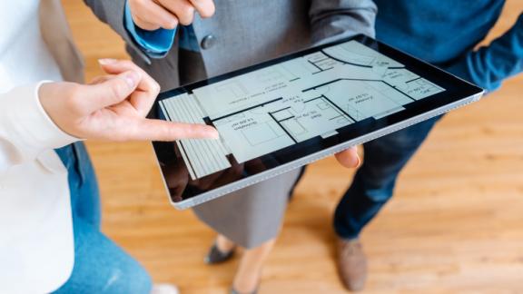 Colleagues discussing a floor plan on an ipad