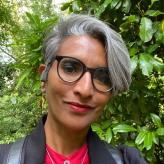 Headshot of Pritti Mehta stood in front of trees