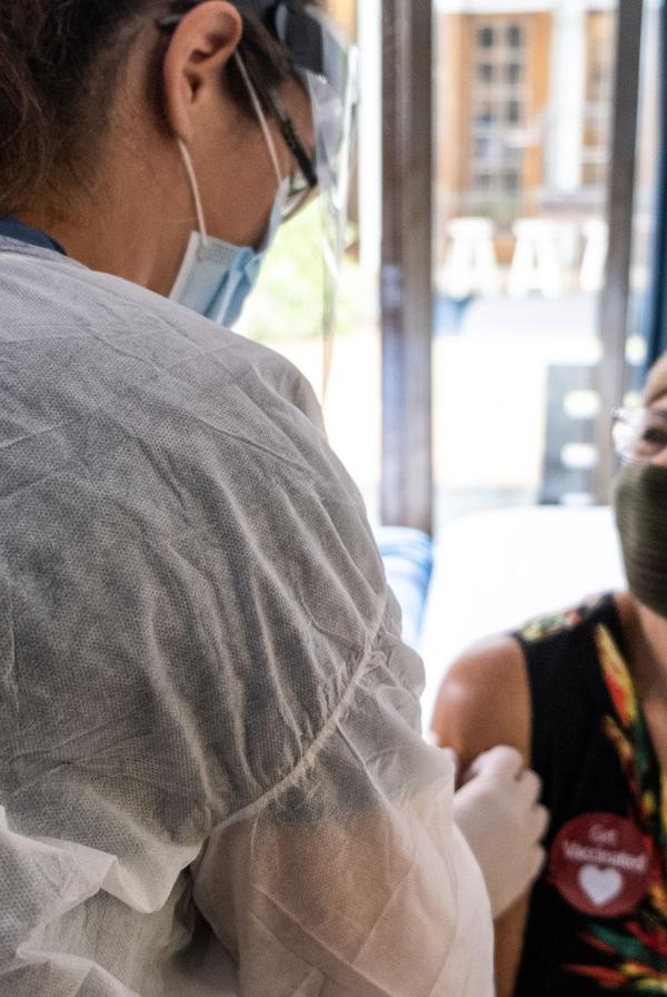 A patient in a mask receives the COVID-19 vaccine.