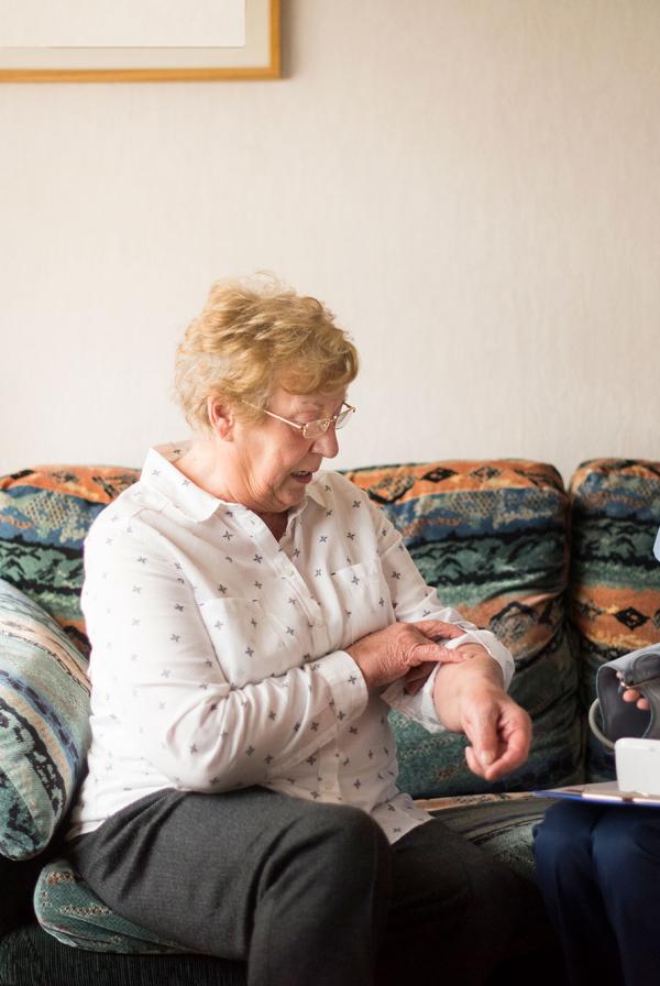 A community nurse checking a patient's temperature.