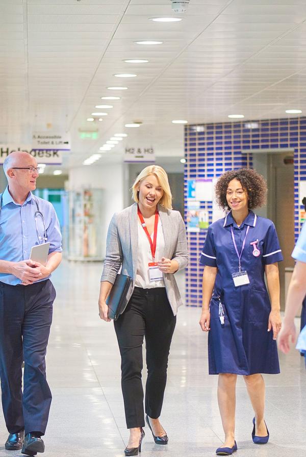 Healthcare workers walking down a hospital corridor.