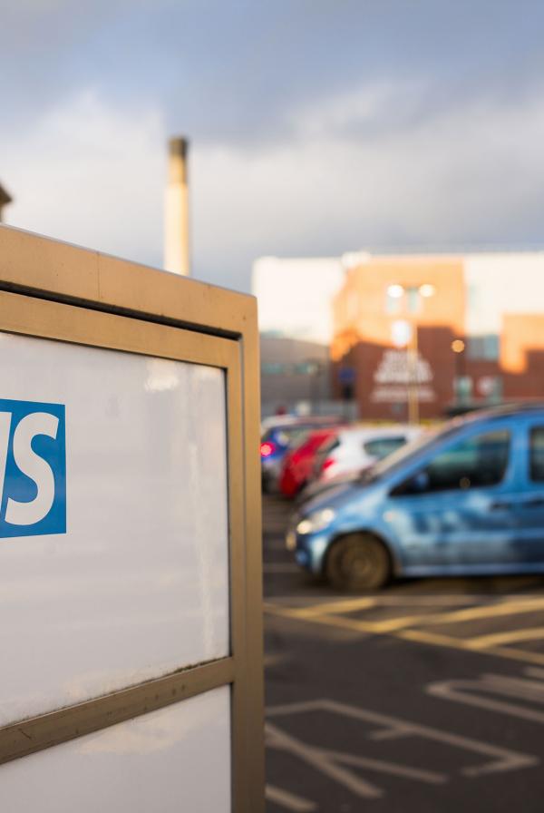 An NHS sign in a car park.