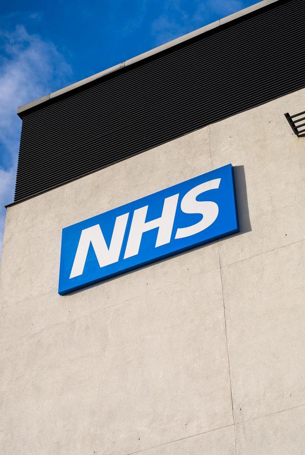 An NHS sign on the side of a building.