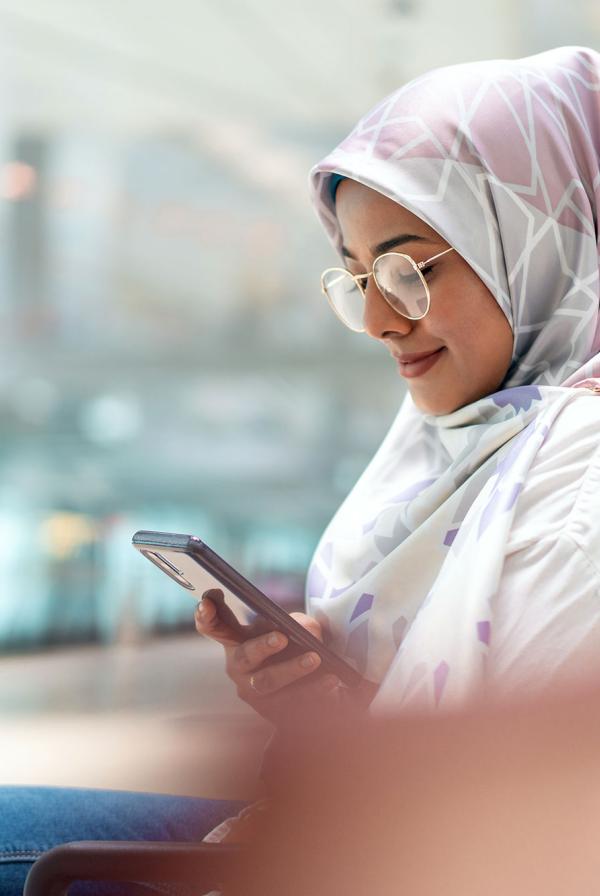 A woman on a bench, checking her phone.