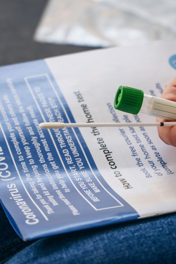 A person holds a COVID-19 testing kit.