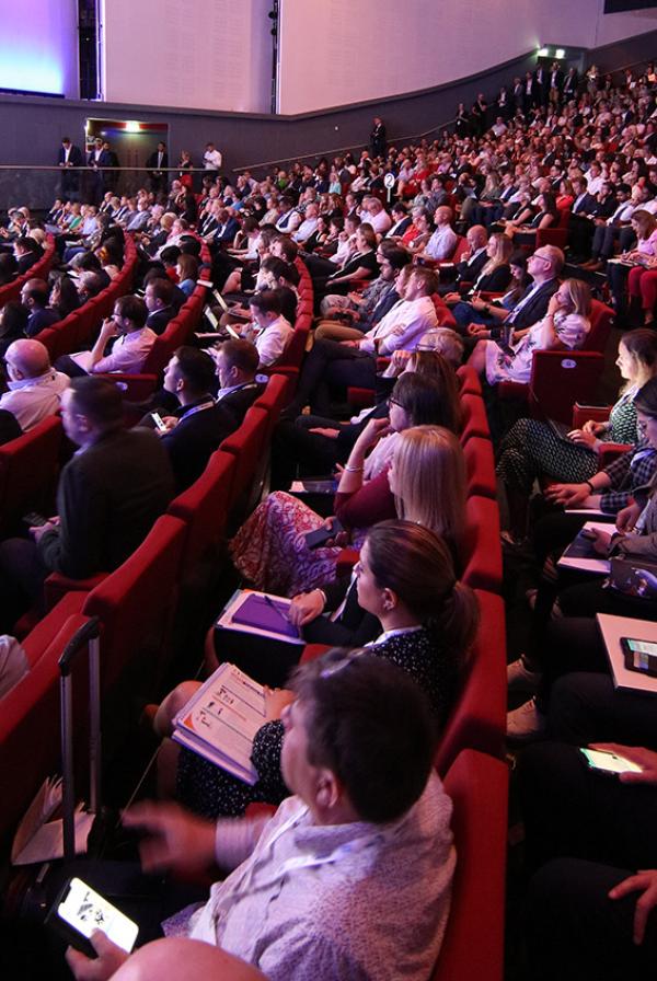 A diverse group of delegates listening to a talk at ConfedExpo 2022.