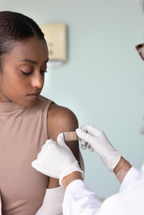 Doctor or nurse giving a young person a vaccination
