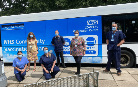 People standing in front of a blue and white bus