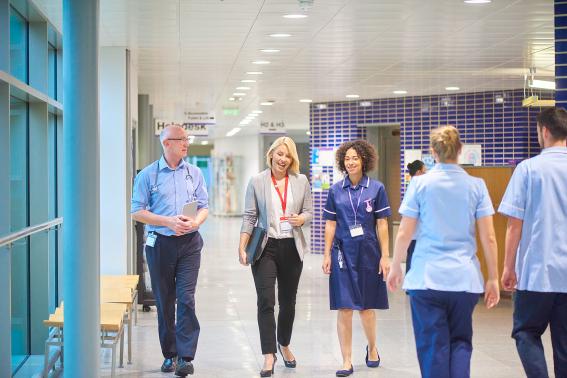 Healthcare workers walking down a hospital corridor.