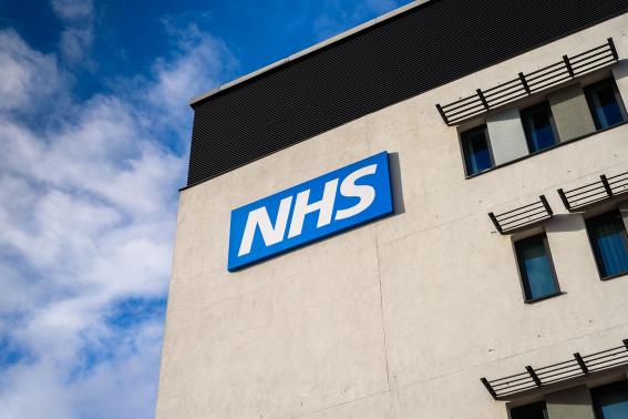 An NHS sign on the side of a building.
